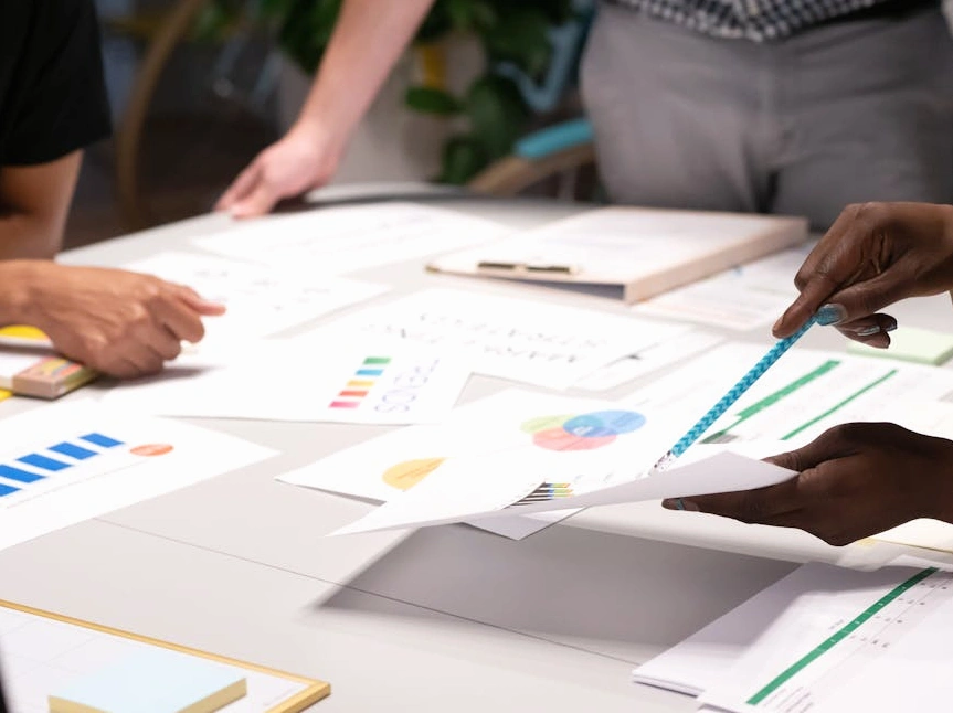 Tým analytiků diskutuje nad dynamickými grafy na obrazovce